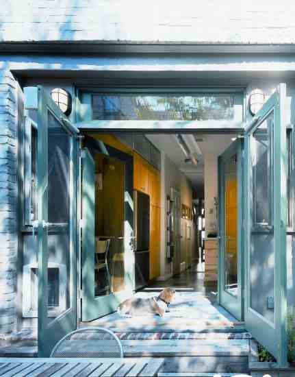 New windows and oversized French doors bring light and air to Scott’s formerly dark kitchen, while blending it with the patio as one continuous space.